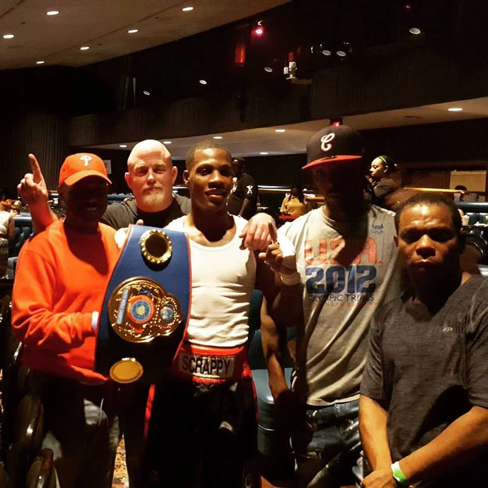 Fight night team celebrating with a championship belt