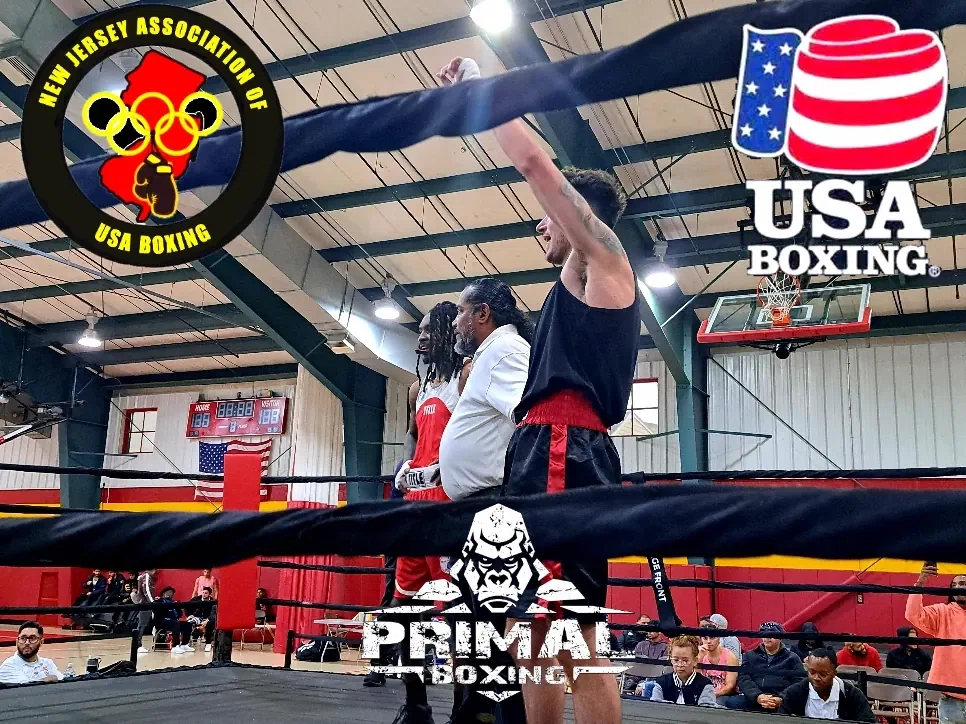 Primal boxer with hands raised after victory in the ring